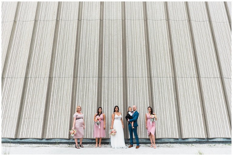 Wedding party in pink dresses standing outside Toronto City hall walls