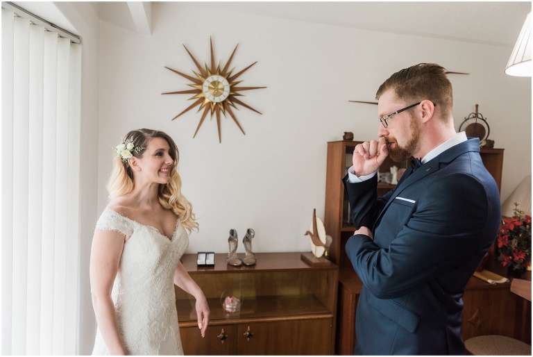 Groom looks at bride when she turns around in awe of her beauty while they get ready together