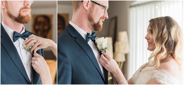 Bride puts on groom's boutonniere while they get ready together on their wedding day 