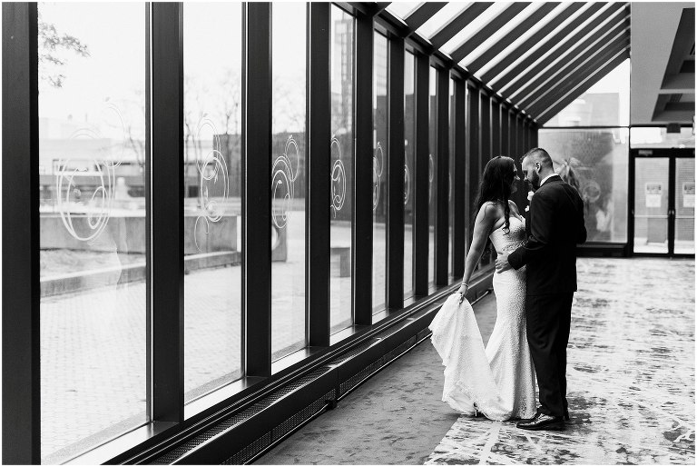 Black and white photo of bride and groom kissing inside Sheraton Hotel Hamilton on their wedding day