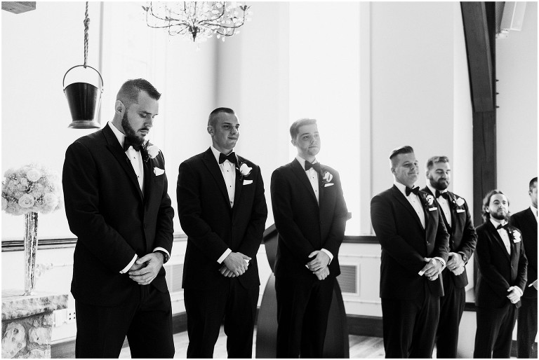 Black and white photo of groom and his groomsmen waiting for bride inside the chapel at the Ancaster Mill on their wedding day
