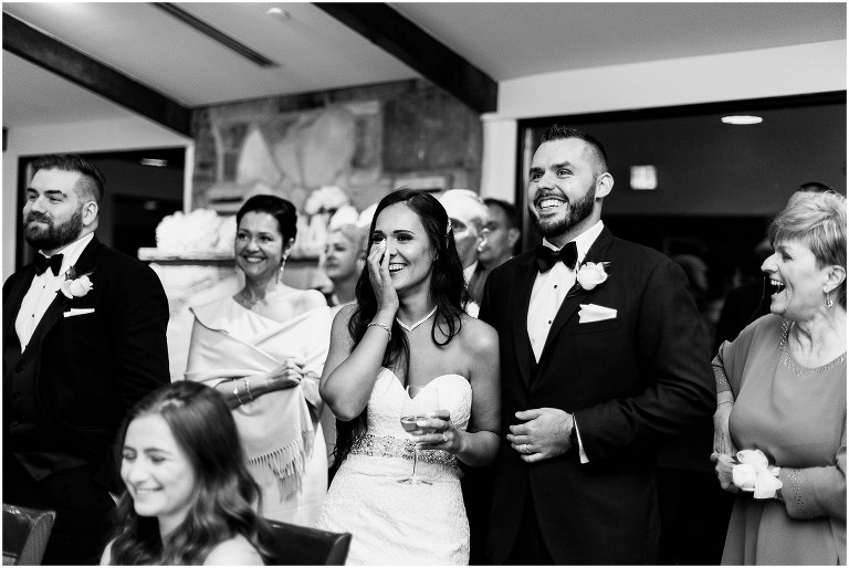 Bride, groom and guests reacting to emotional slideshow being played at their Ancaster Mill wedding