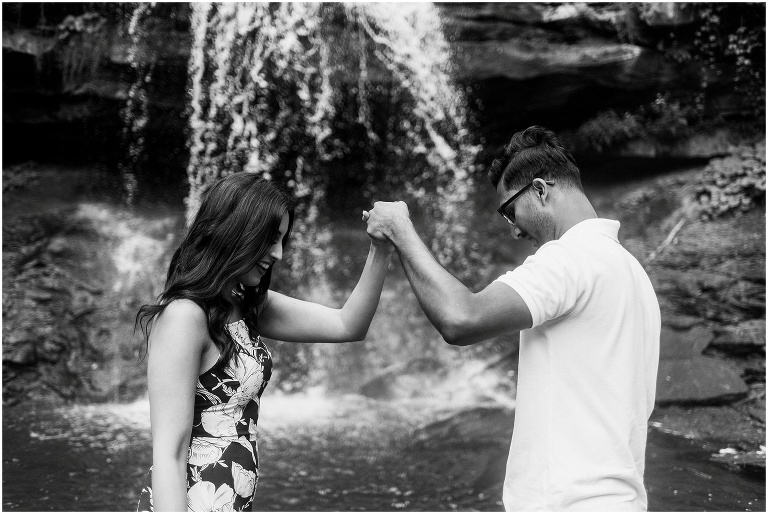 Indian couple chatting and laughing together after their proposal in front of Hamilton waterfall 