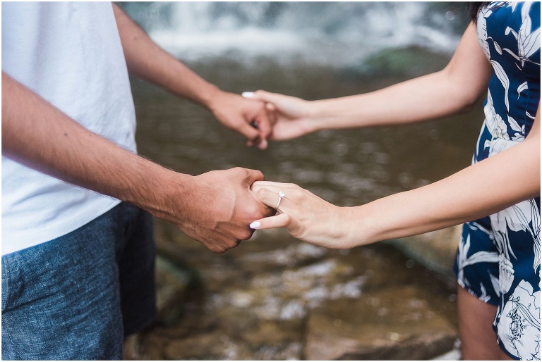 Indian couple holding hands after their proposal in front of Smokey Hollow Waterfall
