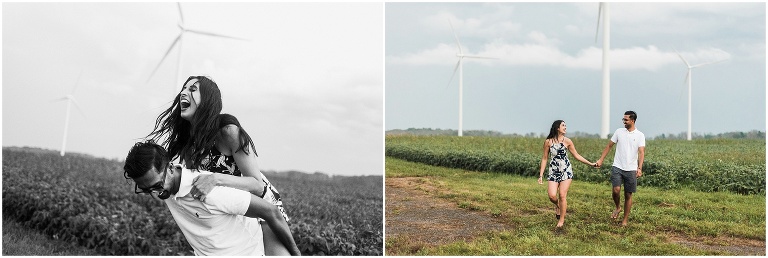 Couple holds hands and runs together in field in front of windmills in Dunnville Ontario for their engagement photos