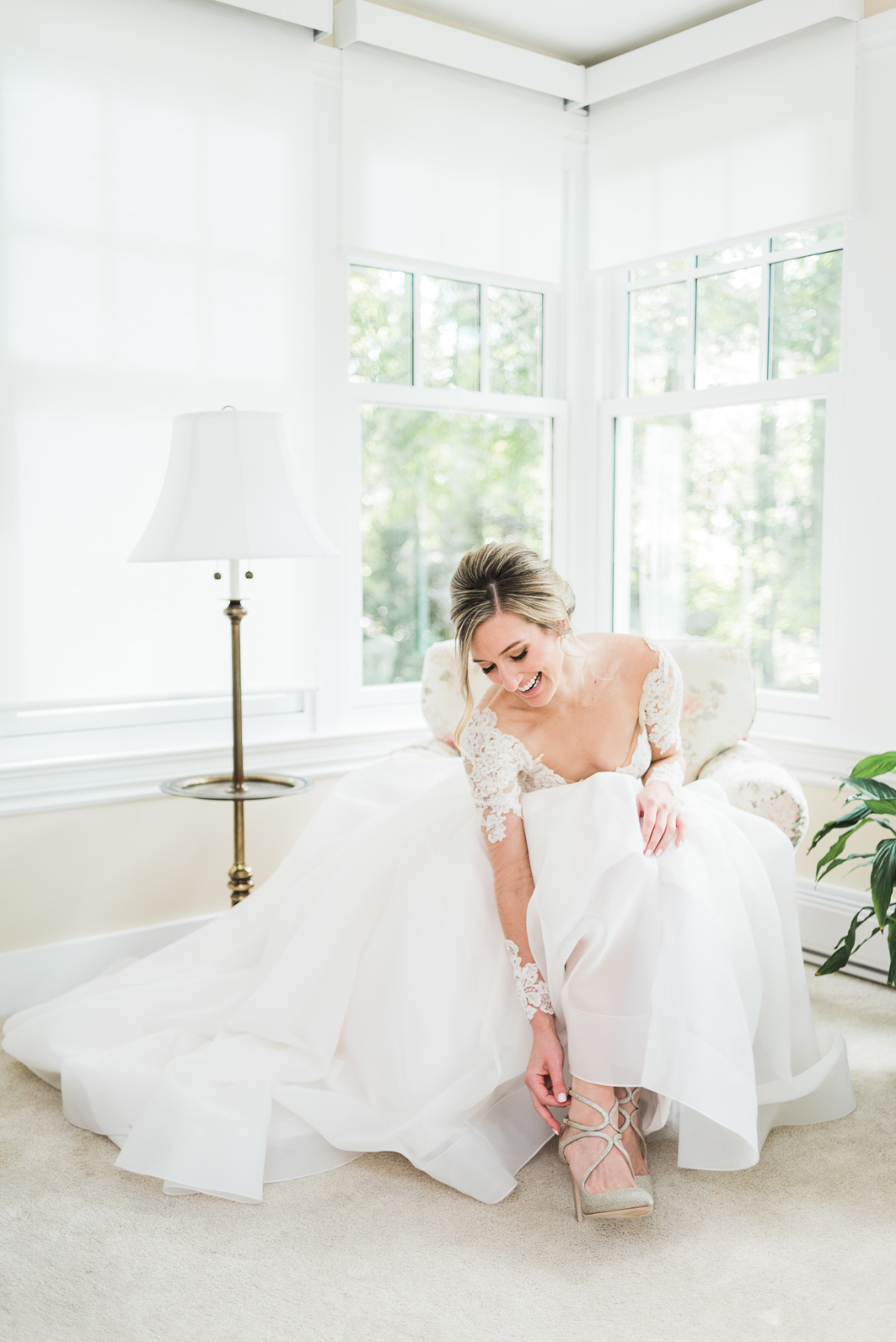 Bride adjusting her shoes while getting ready on her wedding day