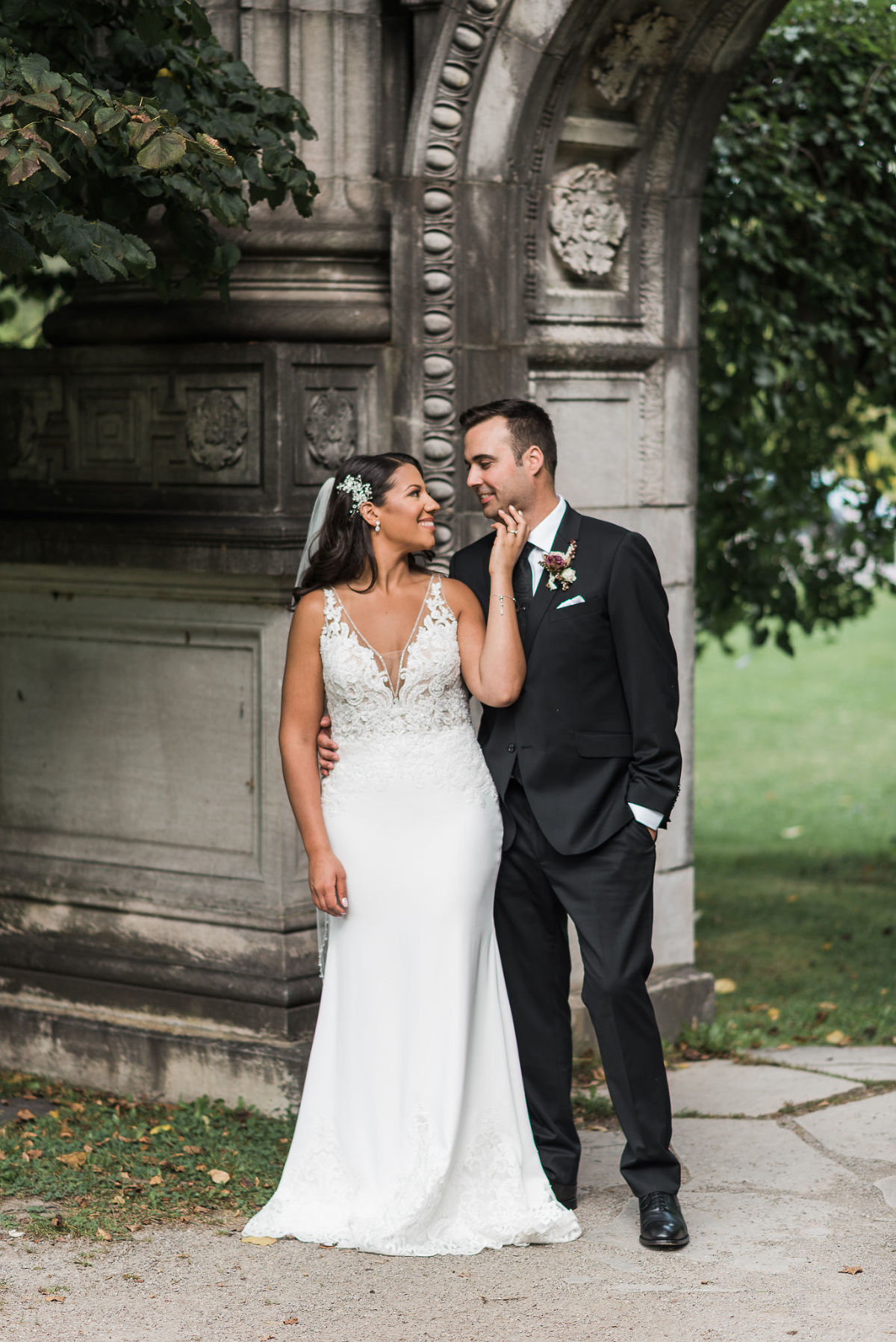 Bride and groom look at each other lovingly in front of ruins at Guild Inn Estate