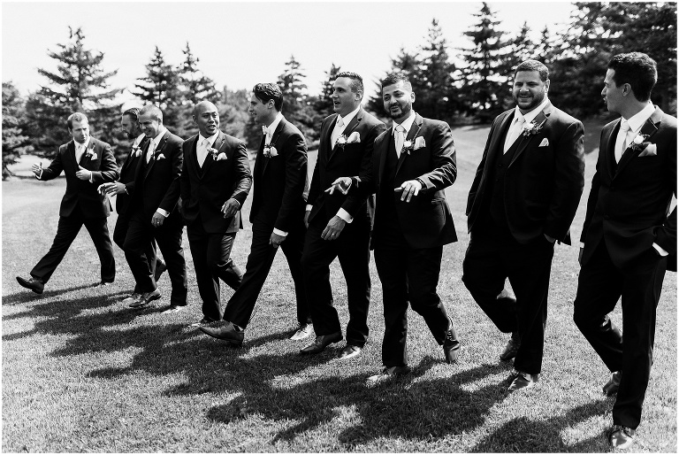 Black and white photo of groomsmen walking on wedding day at The Manor by Peter and Pauls