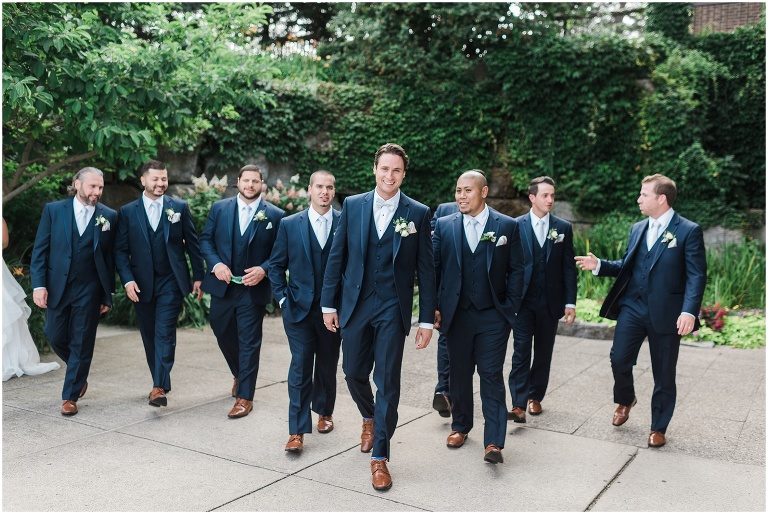Groomsmen walking on wedding day in navy suits at The Manor by Peter and Pauls