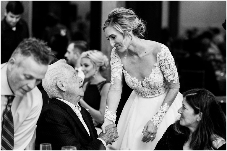 Black and white photo of bride holding her grandfather's hand and looking at him lovingly at elegant Credit Valley Golf and Country Club wedding