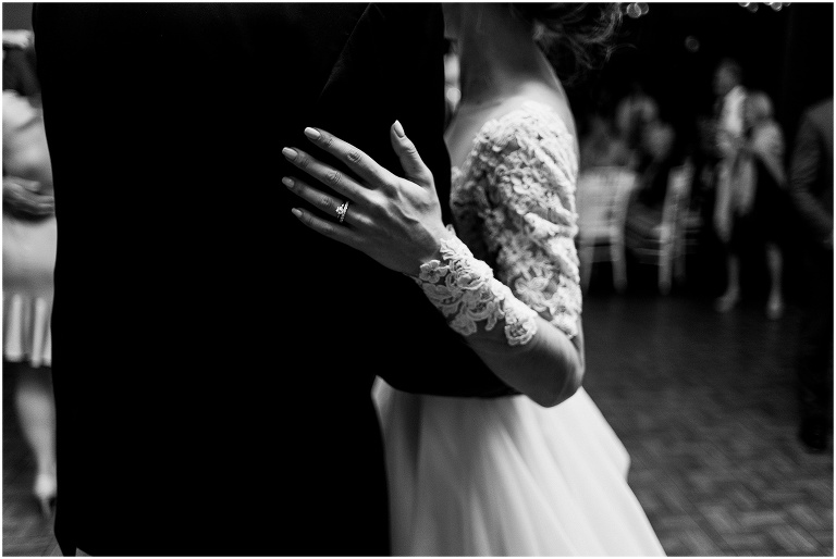 Black and white photo close up of bride's hand on her husbands shoulder with her ring in focus at their elegant Credit Valley Golf and Country Club wedding