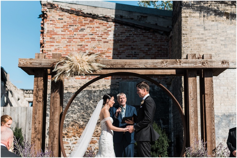 Bride and groom standing together holding hands at Elora Mill wedding at The Riverside Chapel