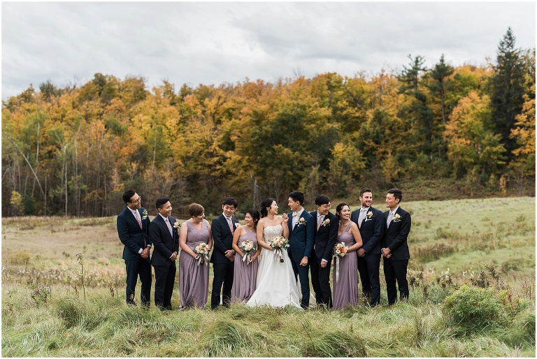 11 person wedding party standing together in field at Scottsdale Farm during autumn