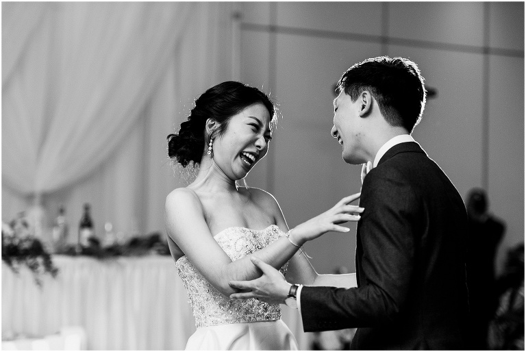 Bride and groom laughing together on the dance floor