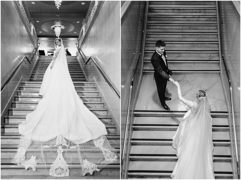Black and white photograph of bride and her massively long wedding veil draping all the way down the staircase at One King West