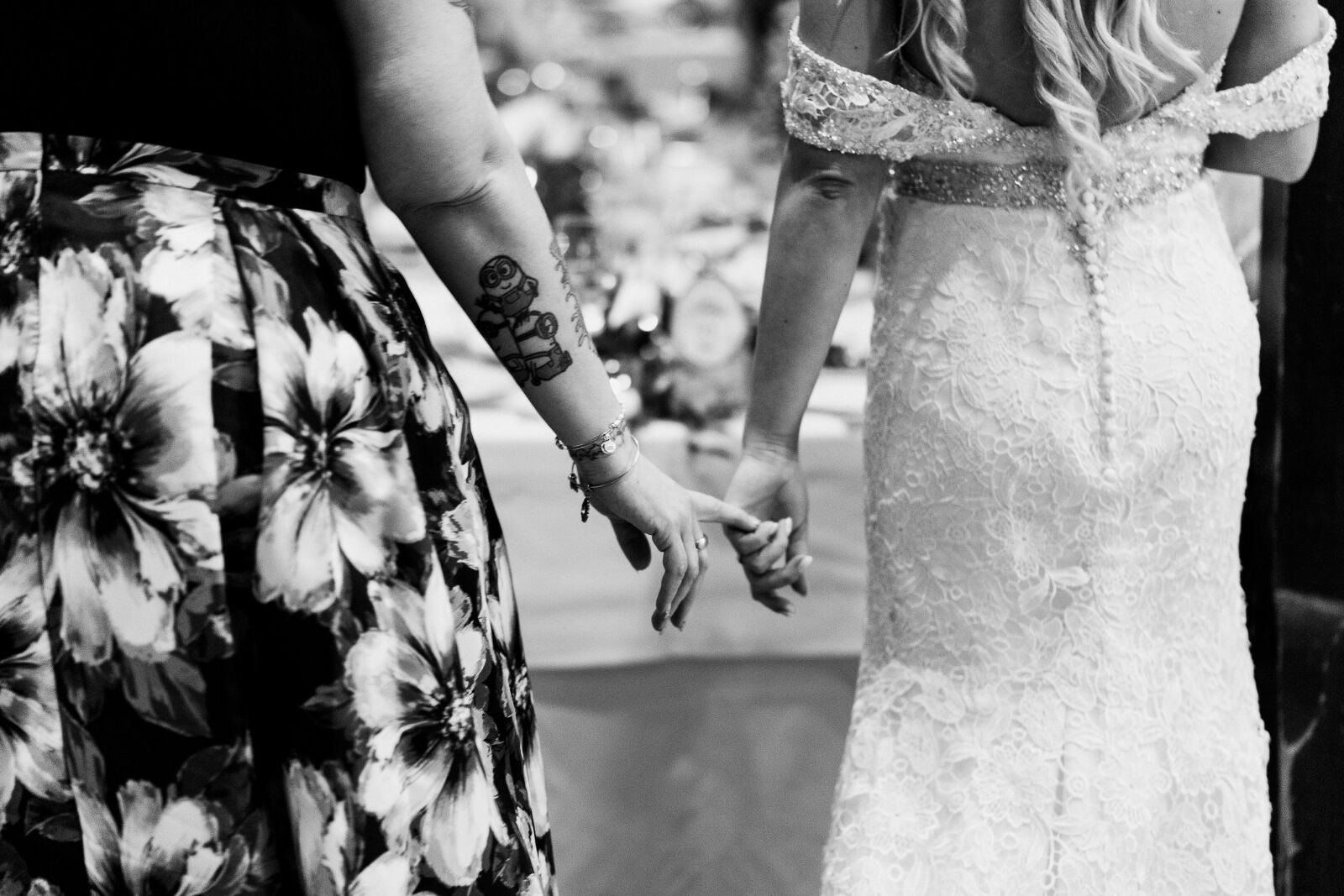 Photo of bride and mom holding their pinky photos together as they walk