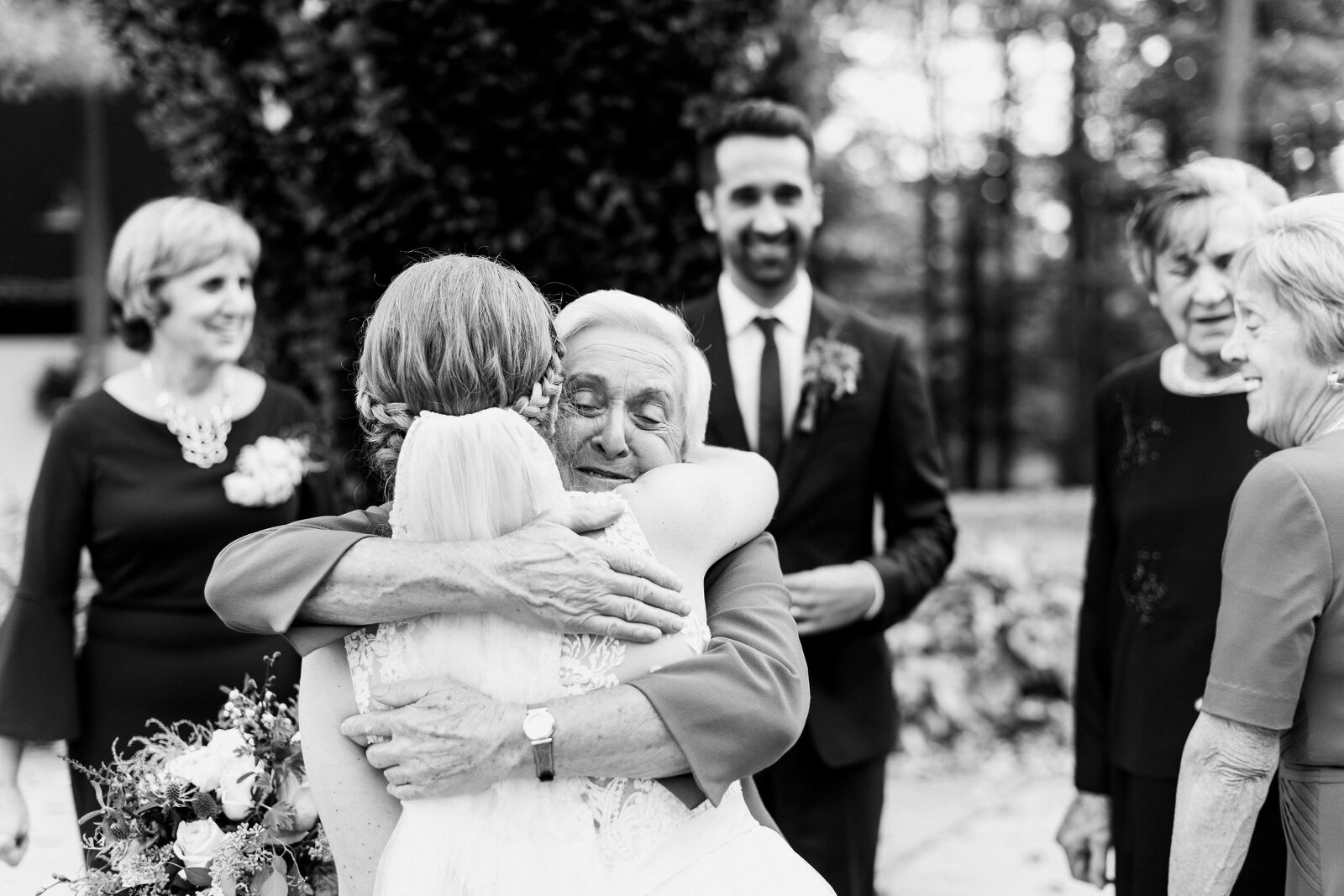 Brides grandmother hugs her tightly on her wedding day