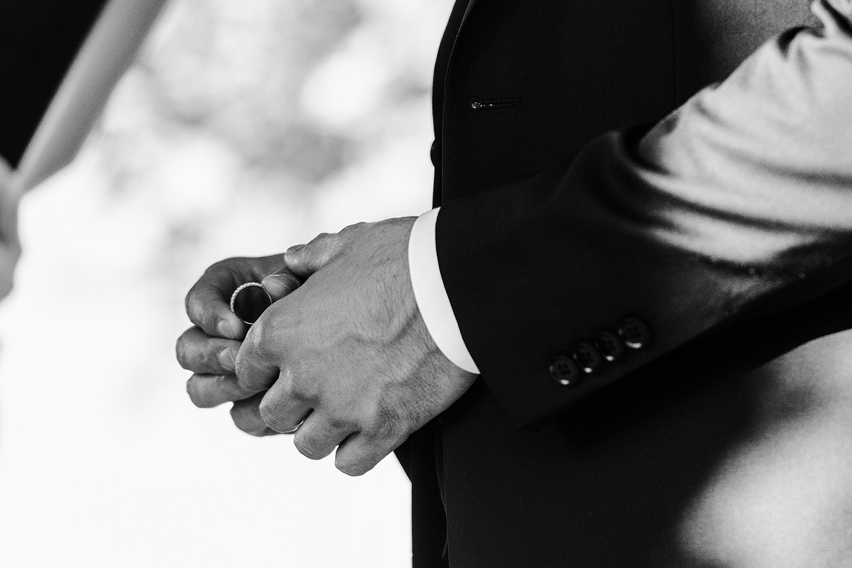 Close up of groom holding his bride's wedding band