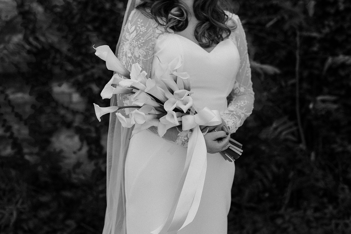 Bride delicately holds her calla lily bouquet across her arms at her Spice Factory Wedding in Hamilton