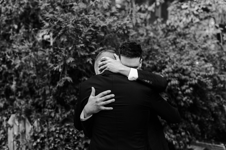 twin brothers hugging after taking photos together