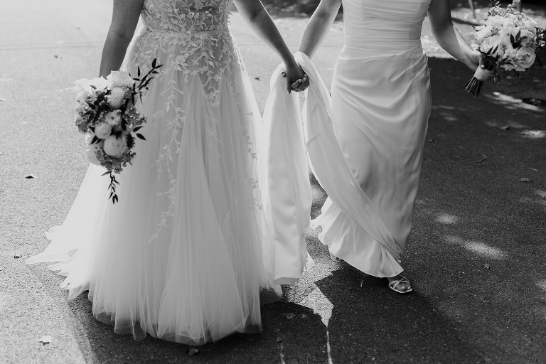 Photo of two brides holding hands and walking